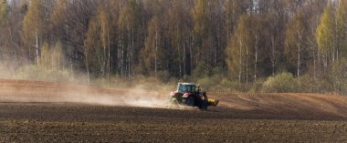 Traktör gündüz sahada çalışıyor.