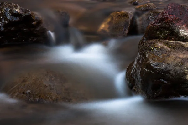 Um pequeno rio com pedras — Fotografia de Stock