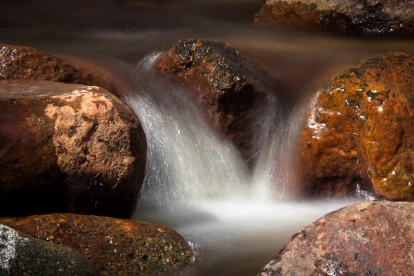 Un pequeño río con piedras — Foto de Stock