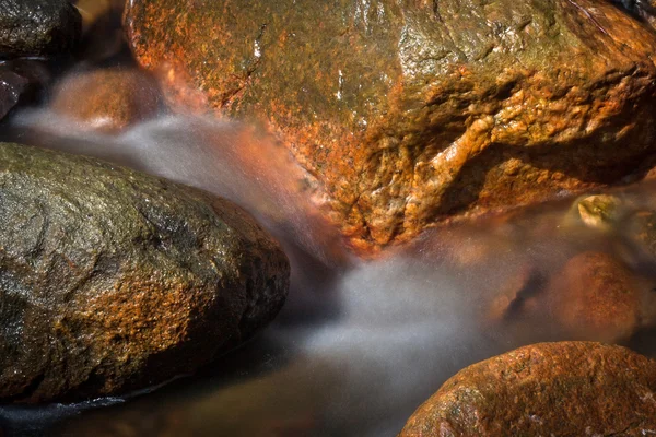 Um pequeno rio com pedras — Fotografia de Stock