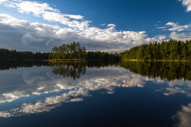 bulutlar ve yansımaları ile orman göl