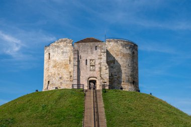 York, North Yorkshire, İngiltere, 14 / 09 / 2020 - Cliffords Kulesi, güneşli bir günde mavi gökyüzü olan bir çimen tepesinde Norman kalesi.
