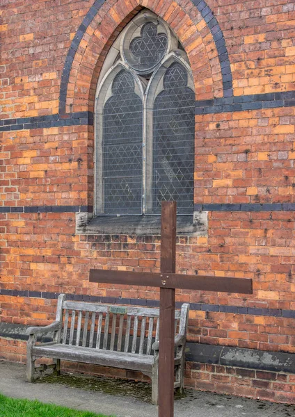木のベンチとアーチ窓のあるチャーチヤードの木製の十字架 — ストック写真