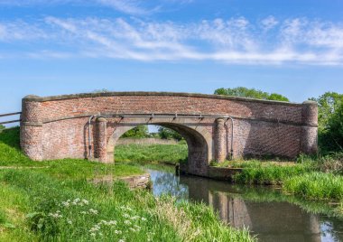 Güneşli bir günde, mavi gökyüzü ve bir kanalın üzerindeki bir köprü..