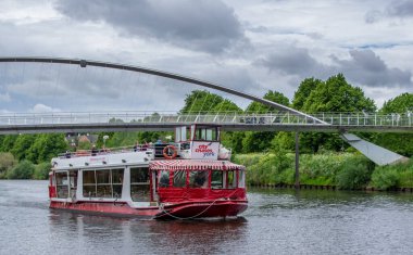 İngiltere, York 'taki Ouse nehrinde tur teknesi, Milenyum Köprüsü' nü geçiyor.