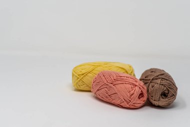 Düz beyaz bir arkaplanda, kopyalama alanı olan üç renkli yün yumak..