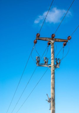 Kablolar ve izolatörlerle dolu ahşap telgraf direği.