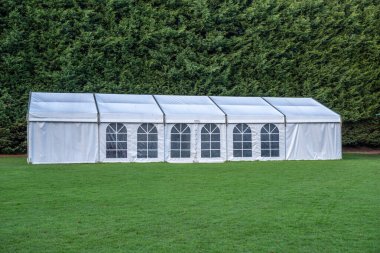 Arka planda yeşil çitli yeşil bir çimenliğe beyaz afiş dikildi.