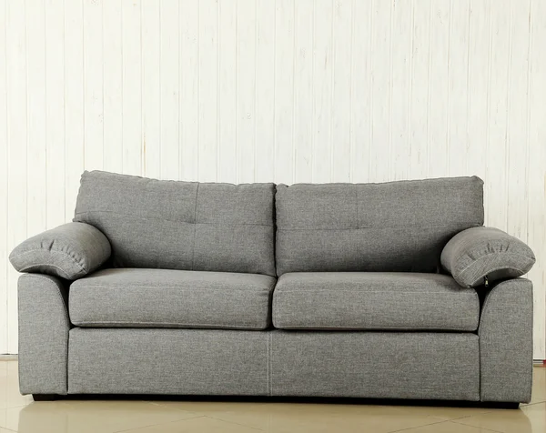 Grey sofa on a white wood wall — Stock Photo, Image