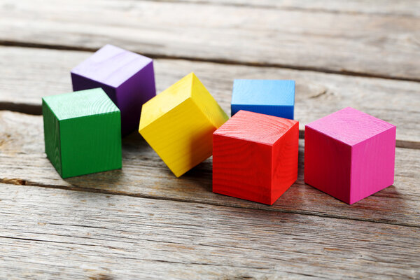 Toy cubes on wooden background 