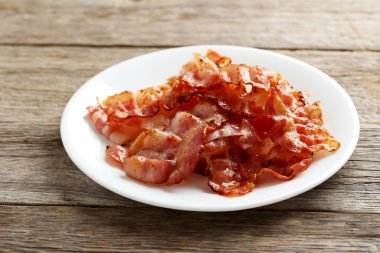 Crispy strips of bacon on plate  clipart