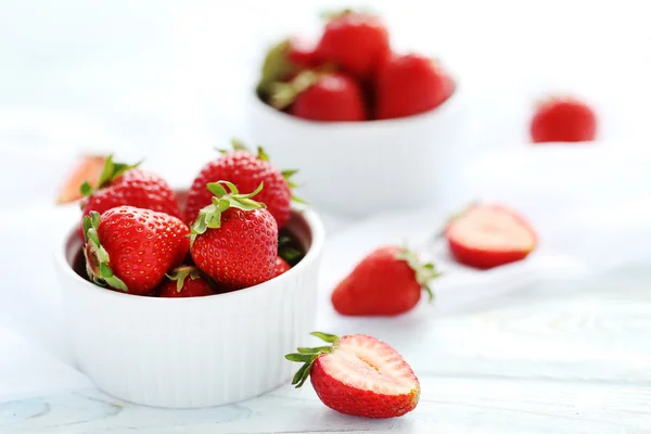 Strawberries in bowl on wooden table — Stock Photo, Image