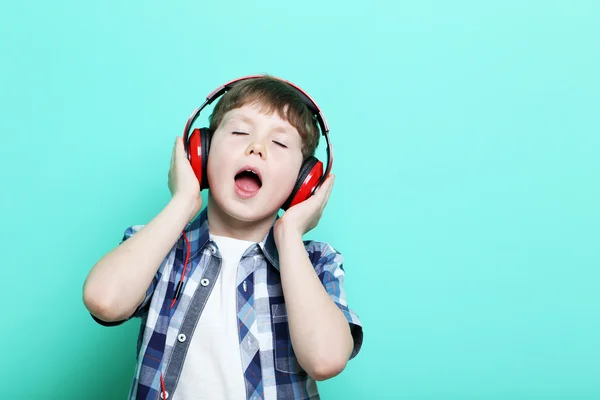 Portrett av en ung gutt med hodetelefoner på mintbakgrunn – stockfoto