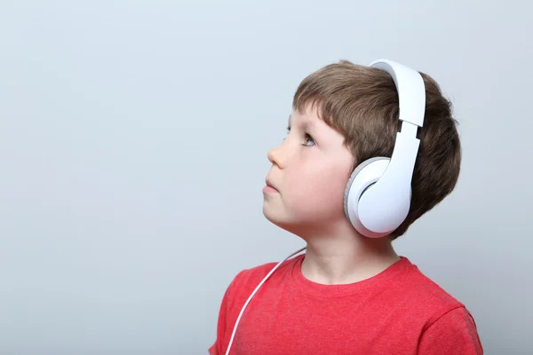 Portrett av en ung gutt med hodetelefoner på grå bakgrunn – stockfoto
