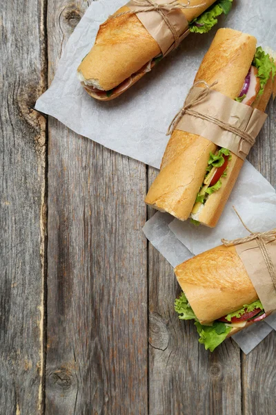 Tasty sandwiches on wooden table — Stock Photo, Image