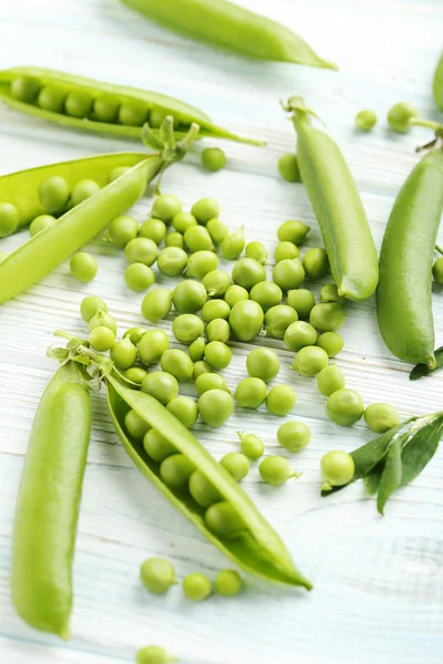 Grüne Erbsen auf Holztisch — Stockfoto