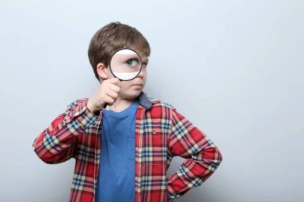 Young boy with magnifying glass — Stockfoto