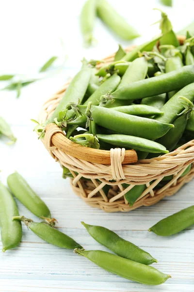 Grüne Erbsen auf Holztisch — Stockfoto