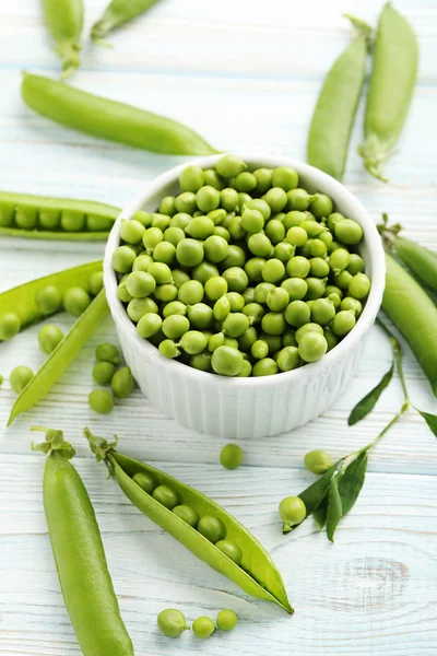 Guisantes verdes en mesa de madera — Foto de Stock