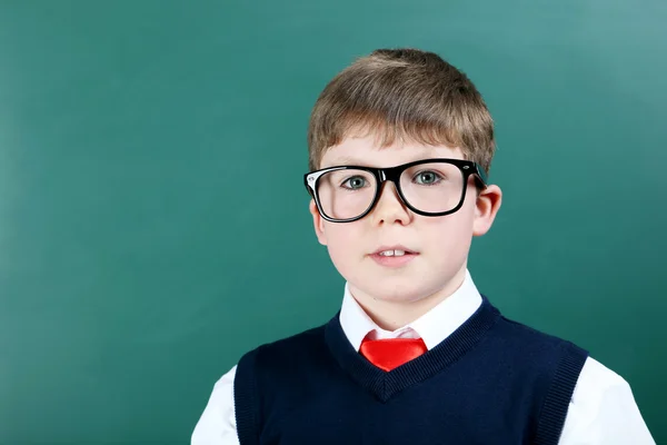 Jonge jongen staat naast het schoolbord — Stockfoto