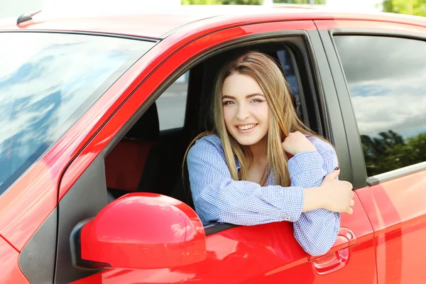 Jovem sentada no carro vermelho — Fotografia de Stock