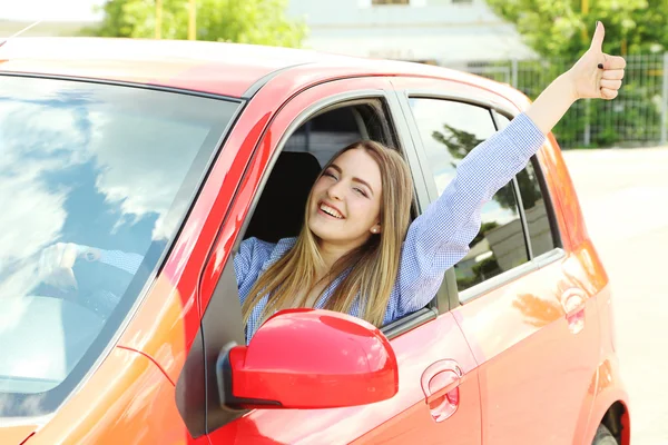 Junges Mädchen sitzt in rotem Auto — Stockfoto