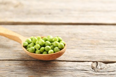 Tahta kaşıkta yeşil bezelyeler