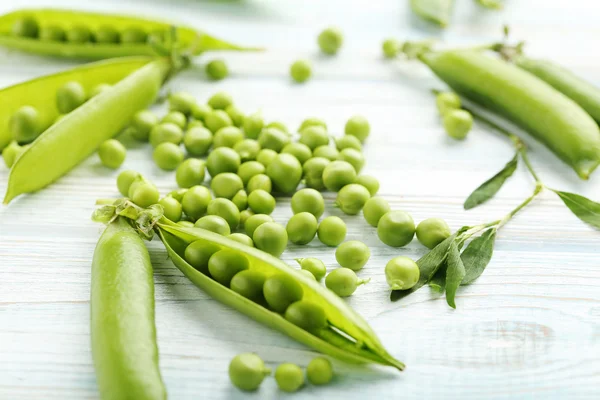 Guisantes verdes en mesa de madera — Foto de Stock