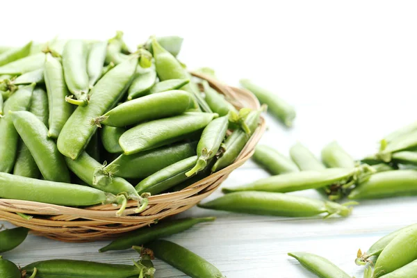 Green peas on wooden table — Stock Photo, Image