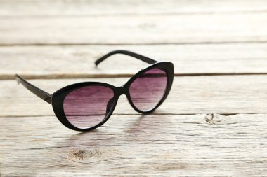 Ahşap masa üzerinde siyah güneş gözlüğü