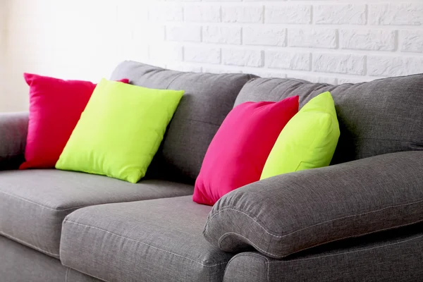 Красочные подушки на сером диване — стоковое фото