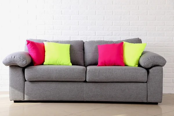 Travesseiros coloridos no sofá cinza — Fotografia de Stock