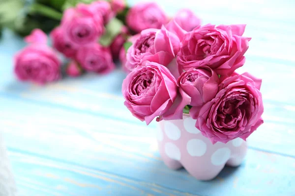 青テーブルにピンクのバラ — ストック写真