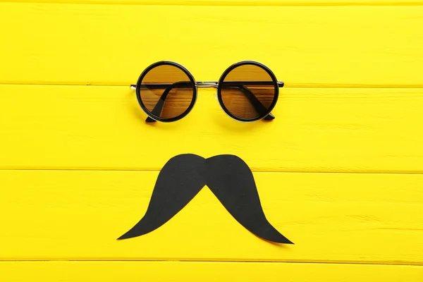 太阳镜和黄色的表上的髭须 — 图库照片