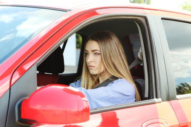 Kırmızı arabada oturan genç kız