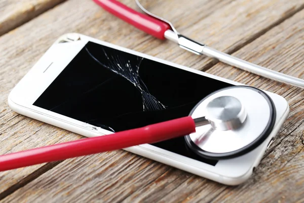 Broken smartphone with stethoscope — Stock Photo, Image