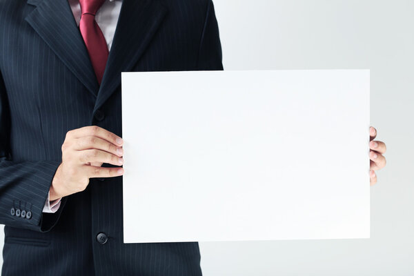 бизнесмен, держащий бланковую бумагу