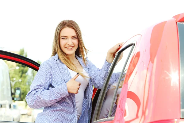 Flickan står nära ny bil — Stockfoto