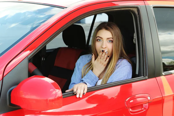Dziewczyna siedzi w czerwony samochód — Zdjęcie stockowe