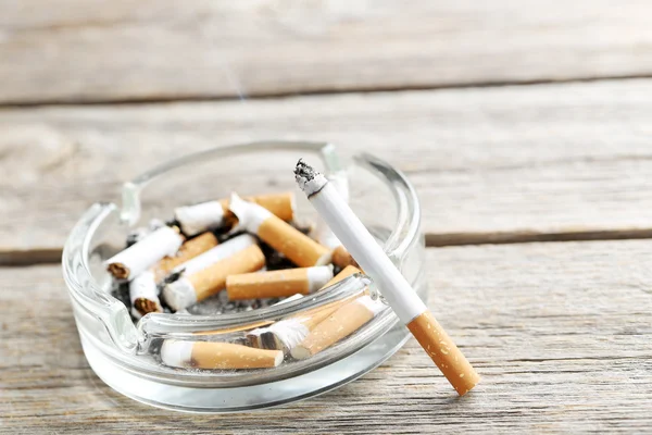 Cigarrillos con ceniza en la mesa —  Fotos de Stock