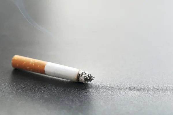 Сигарета з попелом на чорному — стокове фото