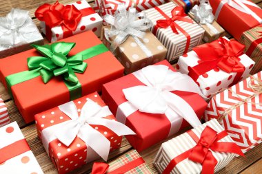 Kahverengi ahşap masada kurdeleli hediye kutuları.