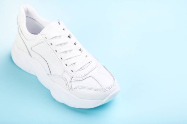 Mavi arka planda beyaz ayakkabı