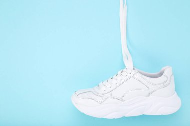 Mavi arka planda beyaz ayakkabı