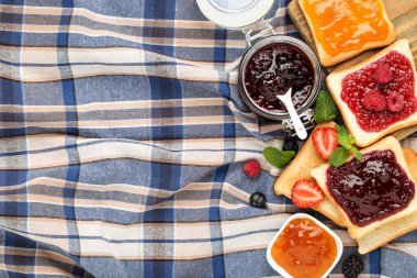 Cam kavanozda reçelli tost ve peçetede nane yaprağı.