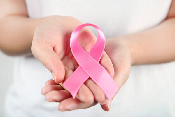 Breast cancer concept. Female hands with pink ribbon