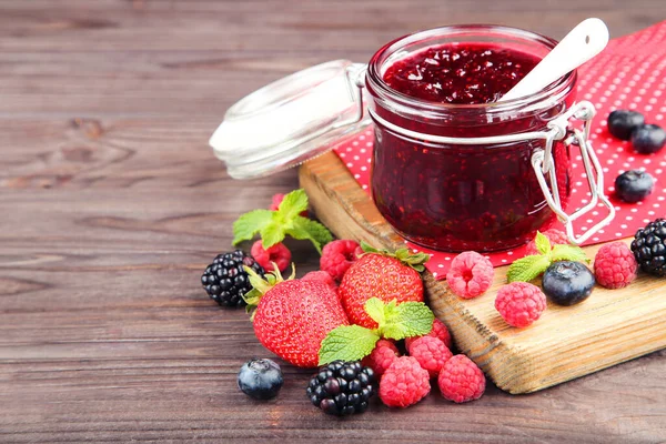 Süße Marmelade Glas Mit Reifen Beeren Auf Braunem Holzhintergrund — Stockfoto