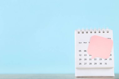 Mavi arkaplanda yapışkan notlu takvim sayfası