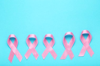 Kanser konsepti. Mavi arkaplanda pembe kurdeleler