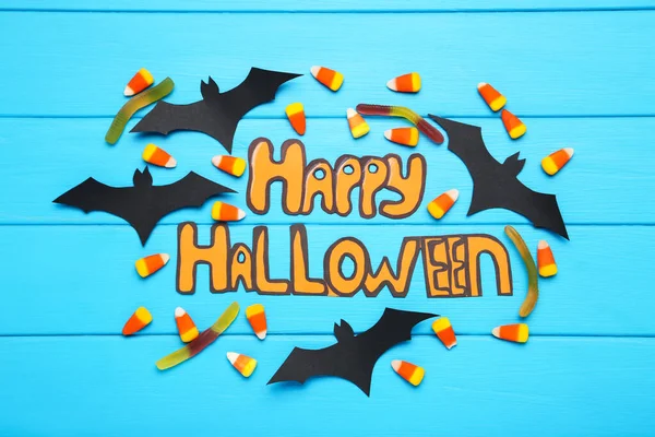 Tekst Happy Halloween Met Papieren Vleermuizen Snoepjes Blauwe Houten Achtergrond — Stockfoto